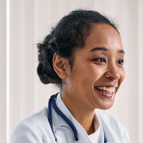 A smiling doctor at her desk.