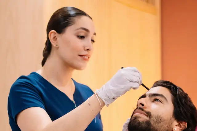 An injector marks a patient's brow before treatment.